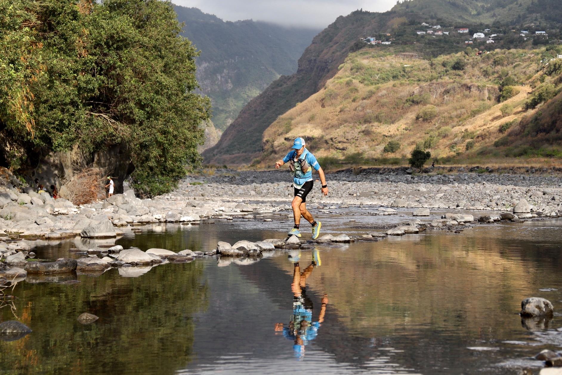 Un coureur traverse la rivière des Galets